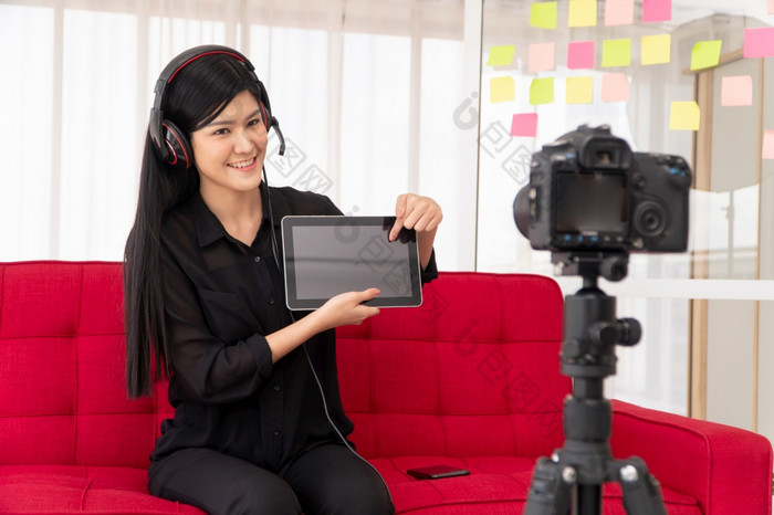 视频博客亚洲女人博主影响者坐着的沙发首页和记录视频博客为教学和教练她的学生订阅者概念的内容创造者在线为新生活方式