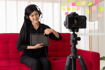 视频博客亚洲女人博主影响者坐着的沙发首页和记录视频博客为教学和教练她的学生订阅者概念的内容创造者在线为<strong>新生活</strong>方式