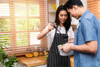 快乐年轻的夫妇站在一起的厨房首页准备在一起晚餐家庭夫妻烹饪的舒适的厨房概念生活方式和夫妇生活后结婚