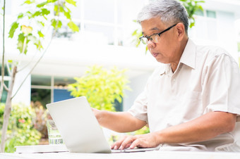 肖像老上了年纪的亚洲男人。使用电脑移动PC的后院为学习新技能后退休概念对<strong>老年人</strong>的歧视和不晚些时候为学习