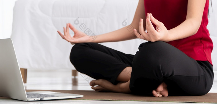 肖像健康的年轻的亚洲女人练习瑜伽练习坐着的卧室和学习在线移动PC首页概念锻炼和放松技术为新正常的生活方式