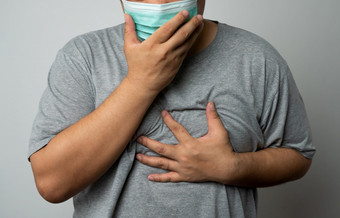 生病的亚洲男人。穿医疗脸面具和咳嗽和覆盖他的口与手概念保护流感大流行冠状病毒和呼吸疾病