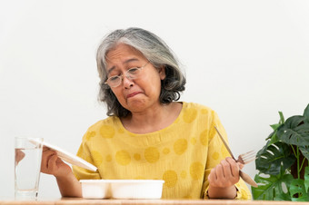 不开心亚洲高级女人厌食症和说准备好了餐上了年纪的首页独自一人和无聊食物和食欲