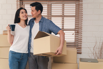 快乐年轻的夫妇携带纸板盒子和走从的前面通过成的房子新房子移动一天概念<strong>搬迁</strong>租赁和房主移动首页