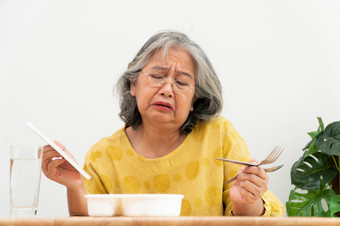 不开心亚洲高级女人厌食症和说准备好了餐上了年纪的首页独自一人和无聊食物和食欲