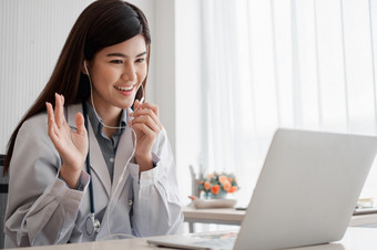 亚洲女人医生在线参观与病人的互联网应用程序和听的症状和解释了如何治疗的最初的疾病概念医疗技术