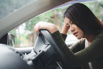 强调和不开心亚洲女人司机坐着内部她的车辆和感觉伤心和愤怒的车事故是引起的疏忽和的司机累了喝醉了和困了女宿醉