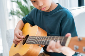 亚洲男孩玩吉他与父亲的生活房间为教学他儿子玩吉他感觉欣赏和鼓励概念快乐家庭学习和有趣的生活方式<strong>爱家</strong>庭关系