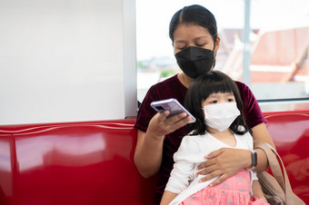 小女孩和妈妈与外科手术面具脸保护流感和病毒爆发公共运输概念新正常的生活方式使用公共运输旅行学校