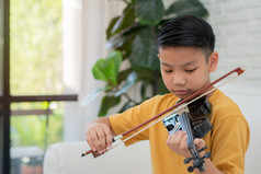 小亚洲孩子玩和实践小提琴音乐的字符串仪器对首页概念音乐的教育灵感少年艺术学校学生