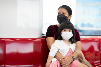 小女孩和妈妈与外科手术面具脸保护流感和病毒爆发公共运输概念新正常的生活方式使用公共运输旅行学校