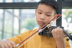 小亚洲孩子玩和实践小提琴音乐的字符串仪器对首页概念音乐的教育灵感少年艺术学校学生