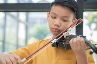 小亚洲孩子玩和实践小提琴音乐的字符串仪器对首页概念音乐的教育灵感少年<strong>艺术学校</strong>学生