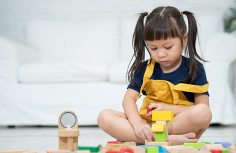 可爱的亚洲小女孩玩与色彩斑斓的玩具块孩子们玩与教育玩具幼儿园托儿所有创意的玩孩子发展概念蹒跚学步的孩子托儿所