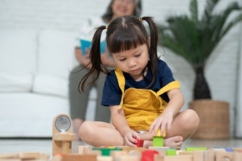 可爱的亚洲小女孩玩与色彩斑斓的玩具块孩子们玩与教育玩具幼儿园托儿所有创意的玩孩子发展概念蹒跚学步的孩子托儿所