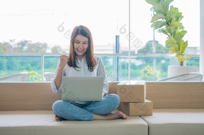 快乐年轻的亚洲女人企业家微笑为销售成功后检查订单从在线购物商店移动PC首页办公室概念商人业务在线和电子商务
