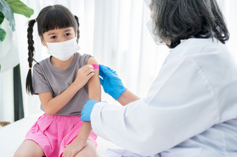医生粘贴的药用石膏后接种疫苗肩膀亚洲女孩孩子们医院儿科医生使疫苗接种为孩子们疫苗接种免疫接种疾病预防概念