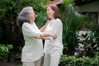 <strong>老</strong>上了年纪的亚洲女人和跳舞的后院与她的女儿概念快乐退休与哪从照顾者和储蓄和高级健康保险快乐家庭