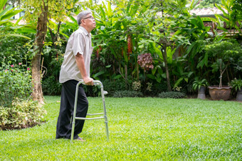 快乐<strong>老</strong>上了年纪的亚洲男人。使用沃克和走的后院概念快乐退休与哪从照顾者和储蓄和高级健康保险