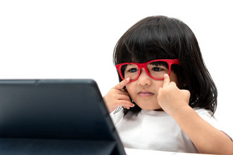 小亚洲学龄前<strong>儿童</strong>女孩穿<strong>红色</strong>的眼镜和使用平板电脑白色背景亚洲女孩会说话的和学习与视频调用与平板电脑<strong>教育</strong>概念为学校孩子们