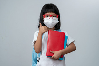 快乐亚洲小学前教育女孩穿红色的眼镜持有书和红色的背包白色孤立的背景概念学校孩子和教育小学和学前教育首页学校