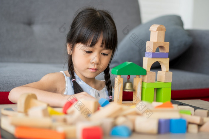 可爱的亚洲小女孩玩与色彩斑斓的玩具块孩子们玩与教育玩具幼儿园托儿所的有创意的玩的孩子发展概念蹒跚学步的孩子的托儿所