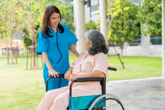 亚洲<strong>小心</strong>照顾者护士持有的病人手和鼓励的病人轮椅概念快乐退休与哪从照顾者和储蓄和高级健康保险