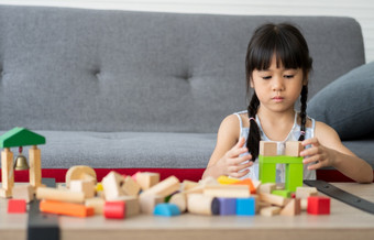 可爱的亚洲小女孩玩与色彩斑斓的玩具块孩子们玩与教育玩具幼儿园托儿所的有创意的玩的孩子发展概念蹒跚学步的孩子的托儿所