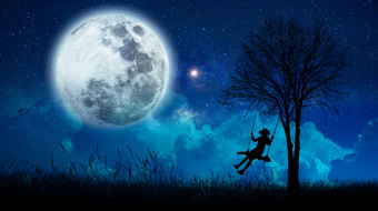 想象力的女孩是抱着在许多星星和完整的月亮晚上