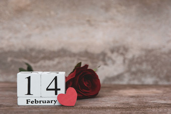情人节一天与2月木白色块日历红色的玫瑰和红色的心木表格背景与复制空间