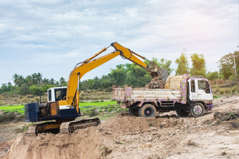 黄色的挖掘机机加载土壤成转储卡车建设网站