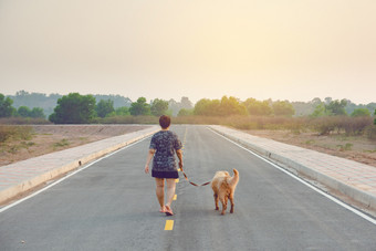 女人与她的金寻回犬狗走的公共路