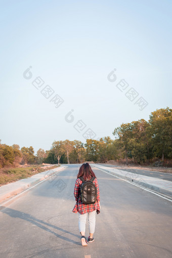 旅行概念旅行女人与背包走沥青路农村