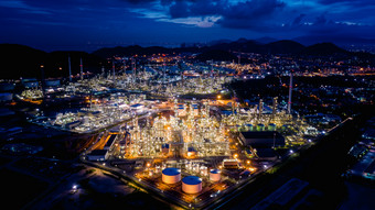 工业区域石油和气体产品炼油厂植物和商店管道晚上在照明与蓝色的天空背景泰国