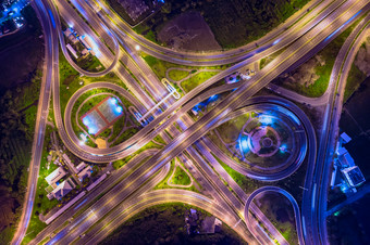 工业环路交通车和高速公路高速公路高速公路晚上时间和照明在色彩鲜艳的空中前视图从无人机