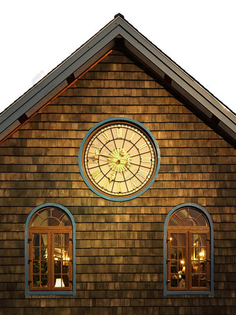 老棕色（的）砖墙房子与两个窗户和时钟和室内照明温暖的古董风格的晚上你隔离背景
