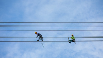 工作人员安装和修改高电压电电缆系统和云天空背景泰国