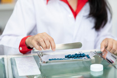 亚洲女药剂师药物计数和包装计数器药店商店泰国