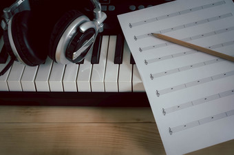 音乐仪器概念背景关闭集团音乐的工具为音乐家创建首歌与的铅笔纸请注意和的电子键盘耳机棕色（的）木复制空间
