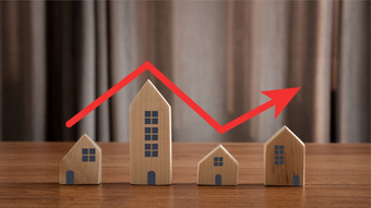 关闭房子模型与红色的箭头指出相同一步楼梯概念真正的房地产财产值增长住房价格增加不断上升的市场投资购买和销售