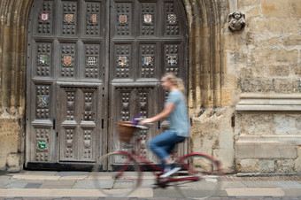 女学生骑老成形自行车周围牛津<strong>大学大学大学</strong>建筑与运动模糊