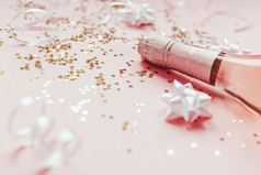 圣诞节新一年作文与瓶玫瑰香槟和金闪亮的闪耀明星五彩纸屑柔和的粉红色的背景一边视图聚会，派对庆祝活动有创意的概念