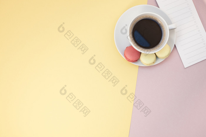 有创意的平躺照片咖啡杯和蛋白杏仁饼和空列表与复制空间粉红色的背景最小的风格