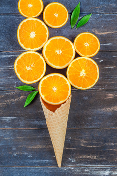 有创意的黑暗风格平躺前视图新鲜的橙色水果片冰奶油华夫格锥棕色（的）木表格背景与复制空间最小的夏天新鲜的柑橘类作文