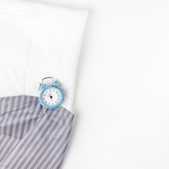 睡眠床上和蓝色的报警时钟孤立的白色背景有创意的概念上的前视图平躺最小的风格休息好晚上失眠放松累了舒适概念