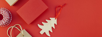 新一年圣诞节礼物包装与丝带平躺前视图圣诞节假期庆祝活动手工制作的礼物盒子红色的纸背景Copyspace模板模型长宽横幅设计