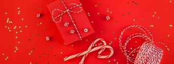 新一年圣诞节礼物包装丝带平躺前视图圣诞节假期庆祝活动<strong>手工</strong>制作的礼物盒子红色的纸金闪光背景<strong>模板</strong>模型问候卡长宽横幅