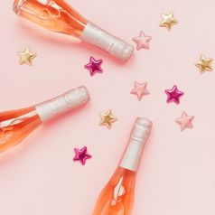 圣诞节新一年作文与瓶玫瑰香槟和金闪亮的闪耀明星五彩纸屑柔和的粉红色的背景前视图庆祝活动平躺聚会，派对有创意的概念