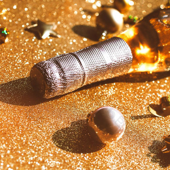 圣诞节新一年作文与瓶玫瑰香槟和金闪闪发光的装饰金闪亮的背景一边视图与节日散景和阴影聚会，派对庆祝活动有创意的概念