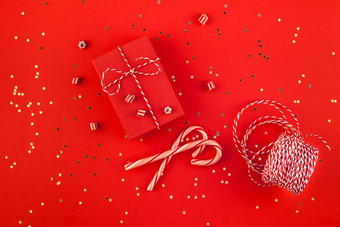 新一年圣诞节礼物包装丝带平躺前视图圣诞节假期庆祝活动<strong>手工</strong>制作的礼物盒子红色的纸金闪光背景<strong>模板</strong>模型问候卡你的文本设计